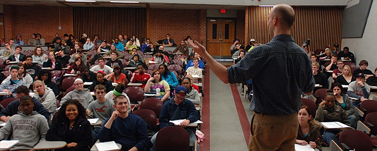 graduate assistant teaching a course in auditorium