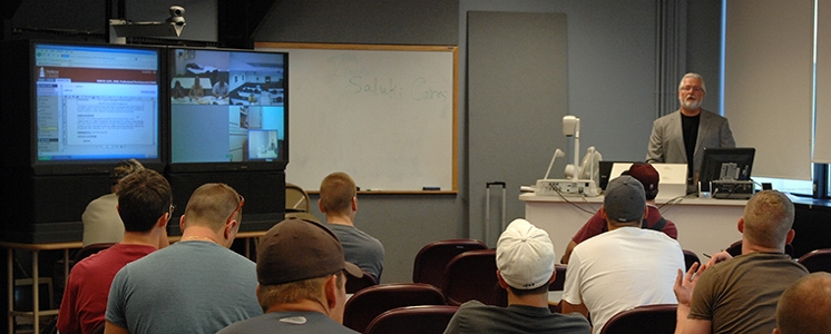 Instructor teaching live class with additional students via videoconference.